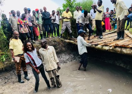 Smiling together after a job well done. This photo captures a moment of shared pride between community members and leadership, celebrating the dedication of the local men who collaborated on restoring the area's essential water source.
